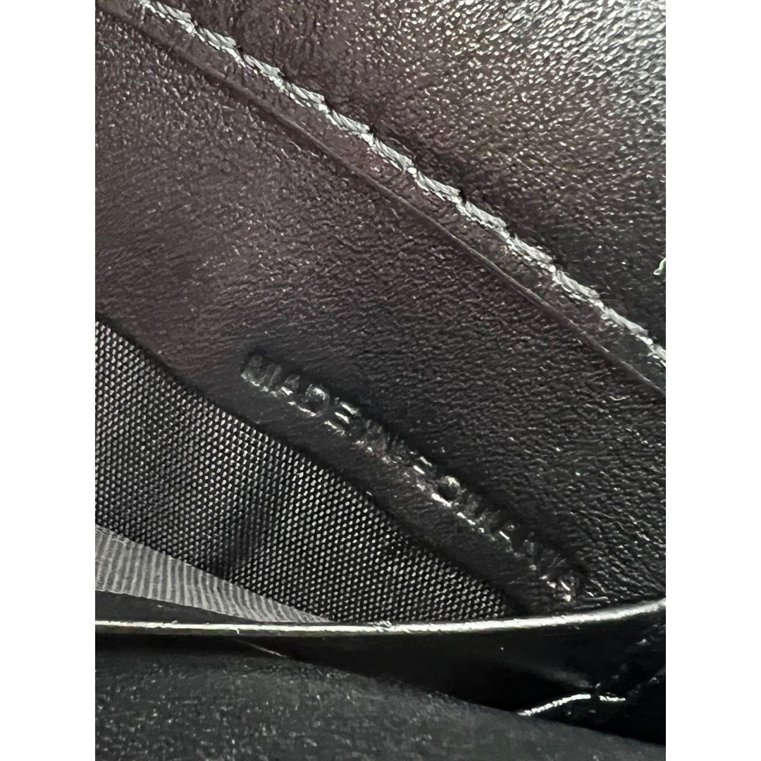 Close-up of a black leather product with 'Made in Italy' stamp