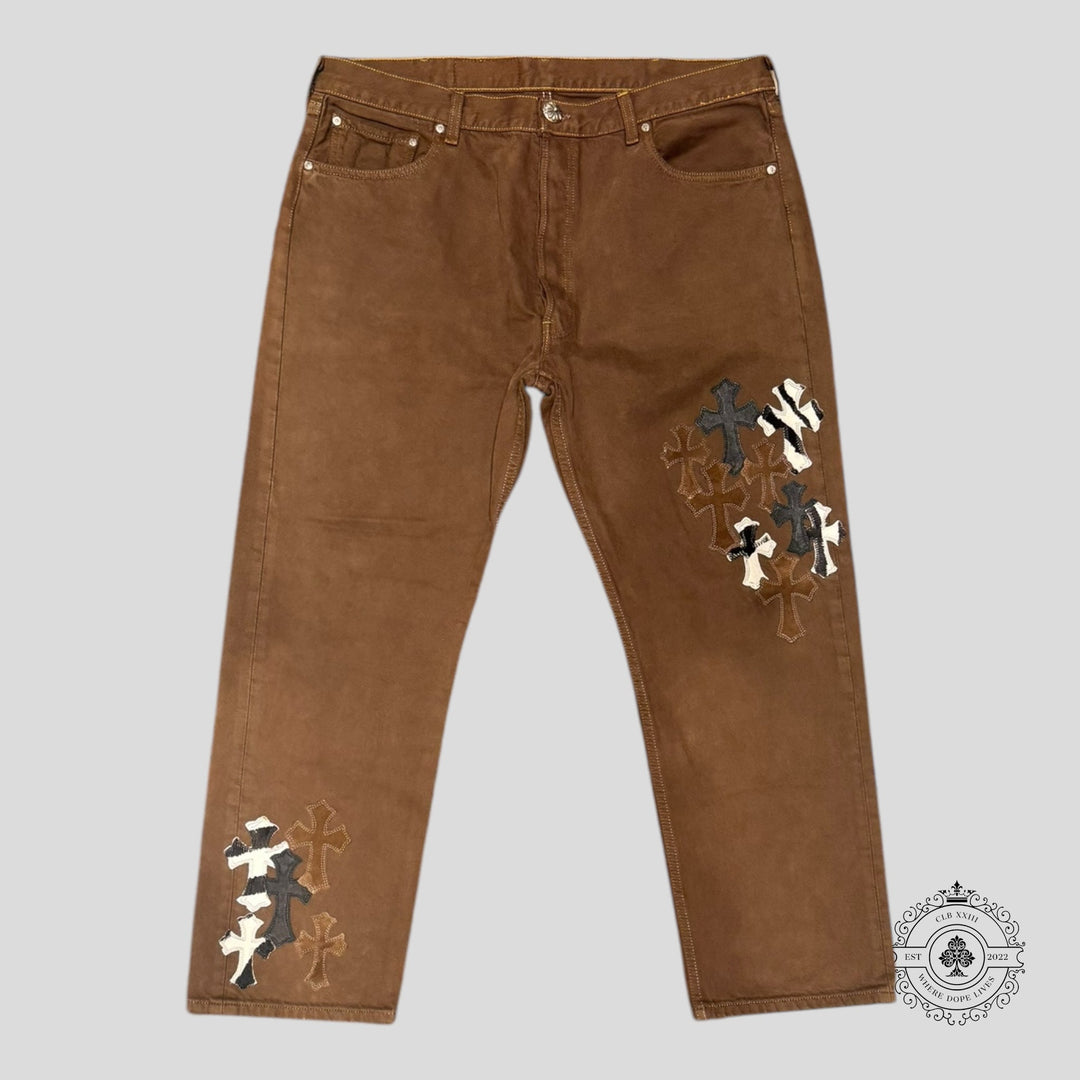 Brown pants with embroidered designs on a gray background