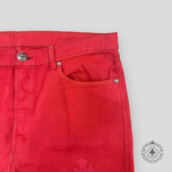Close-up of red pants with a button and zipper on a light gray background