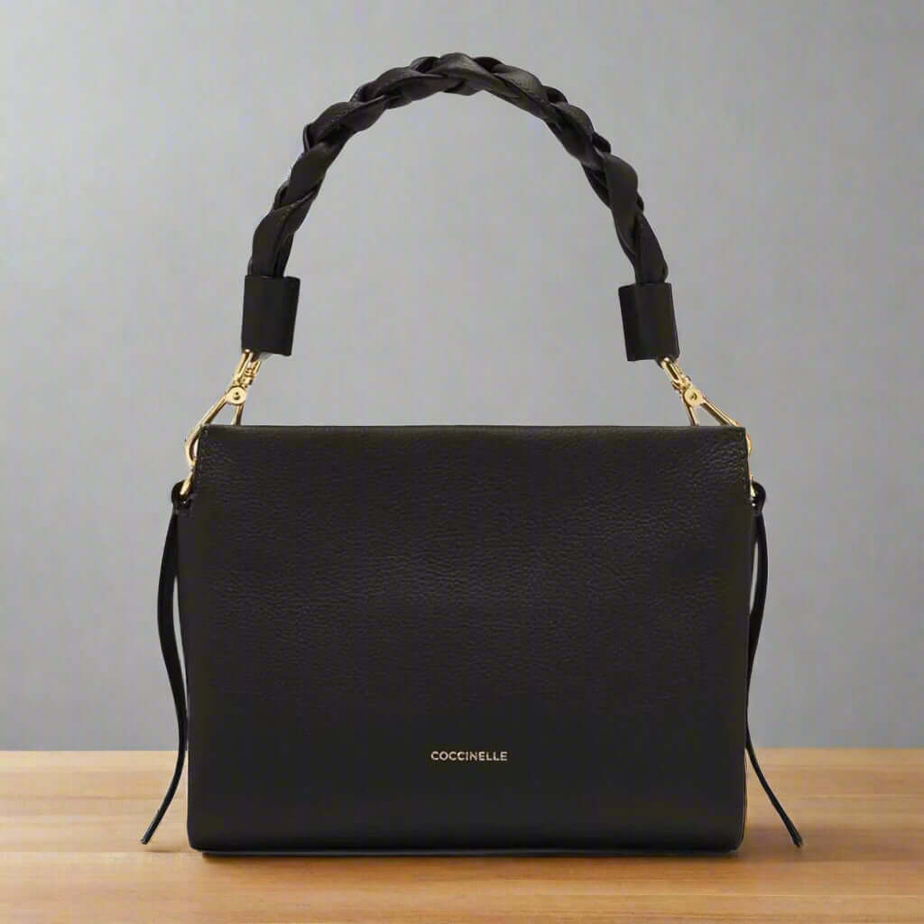 Black handbag with braided handle on a white background