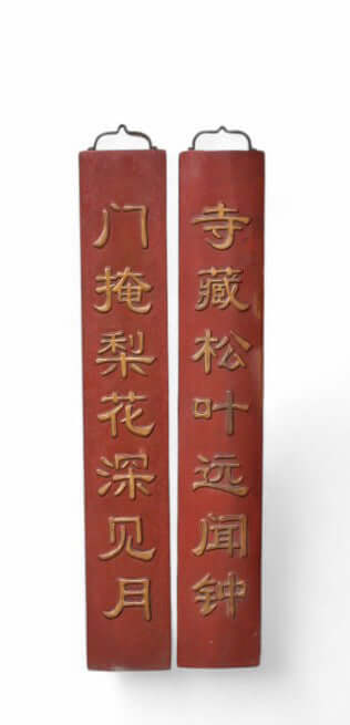 Pair of red wooden couplets with Chinese characters on a white background