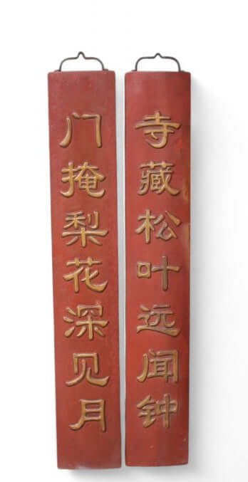 Pair of red wooden couplets with gold text on a white background