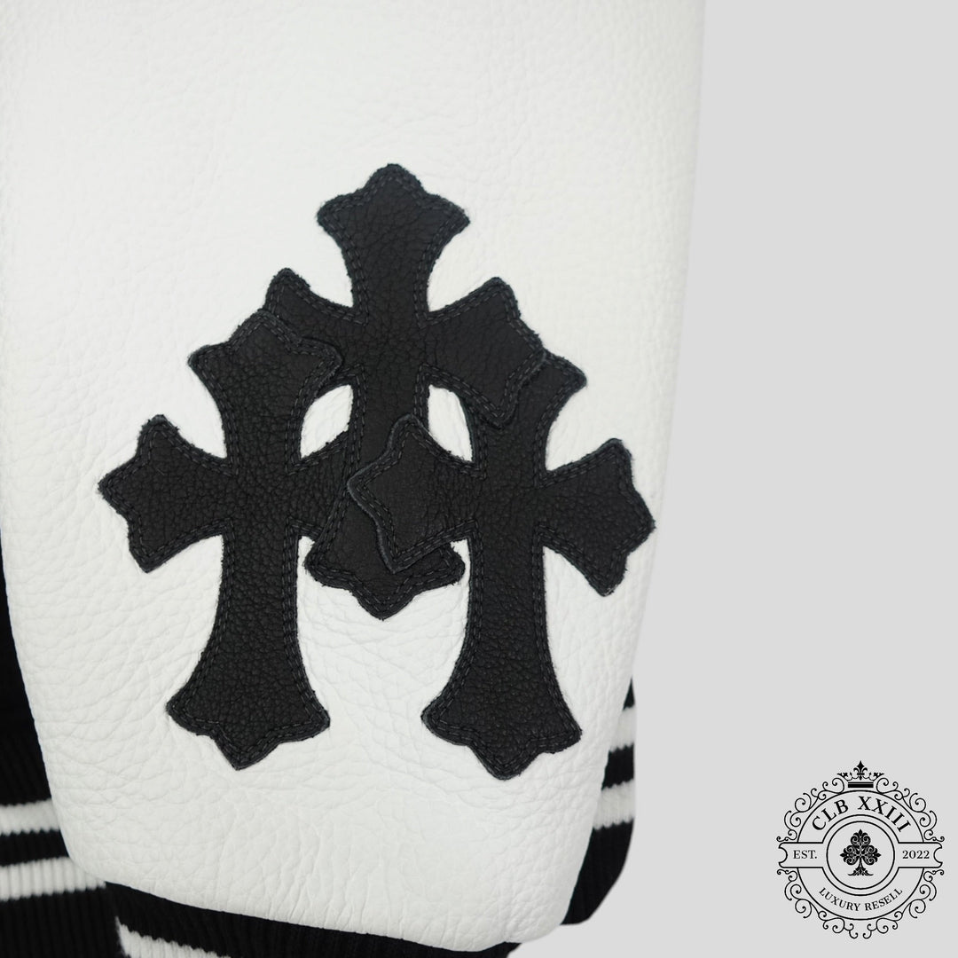 Close-up of a white garment with black cross patterns and a brand logo in the corner.