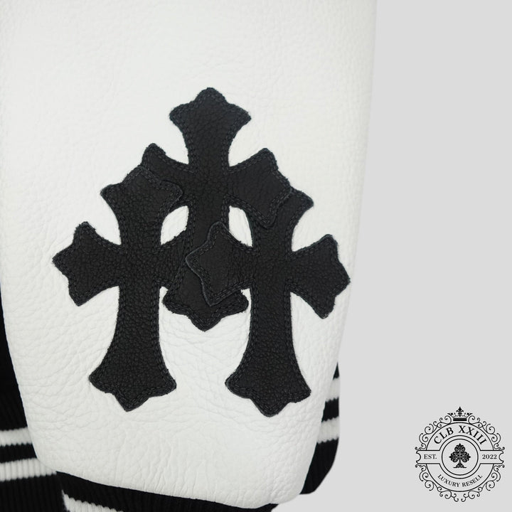 Close-up of a white garment with black cross patterns and a brand logo in the corner.