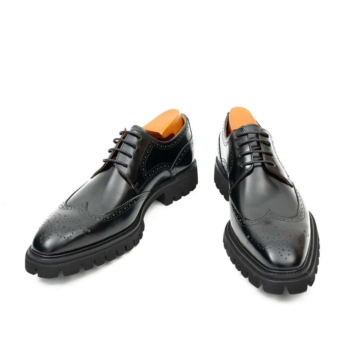 Black derby brogue shoes by DV DIVINCH, handcrafted calfskin footwear, featuring intricate detailing and a cushioned sole.