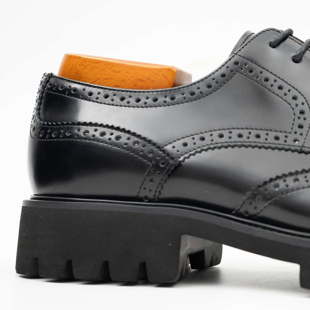 Black derby brogue shoes by DV DIVINCH, featuring polished calfskin leather and detailed brogue design with cushioned lug sole.