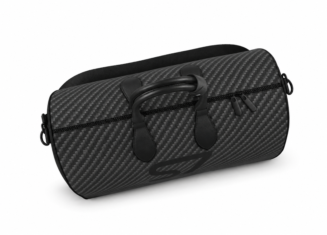 S7 Carbon Noir leather duffle bag with a graphite carbon-fiber-inspired print, centered black S7 monogram, black handles and solid black end panels.