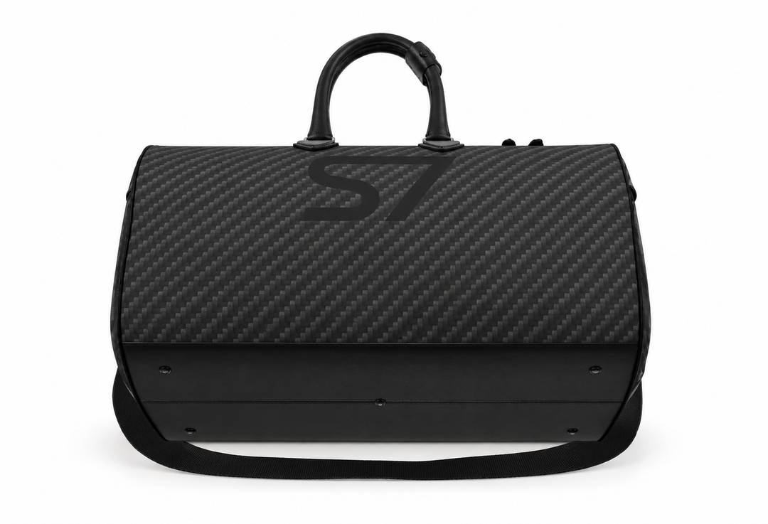 S7 Carbon Noir leather duffle bag with a graphite carbon-fiber-inspired print, centered black S7 monogram, black handles and solid black end panels.