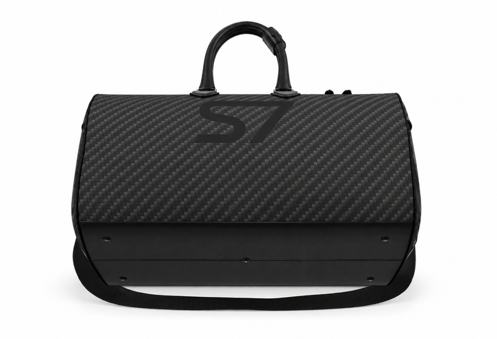 S7 Carbon Noir leather duffle bag with a graphite carbon-fiber-inspired print, centered black S7 monogram, black handles and solid black end panels.