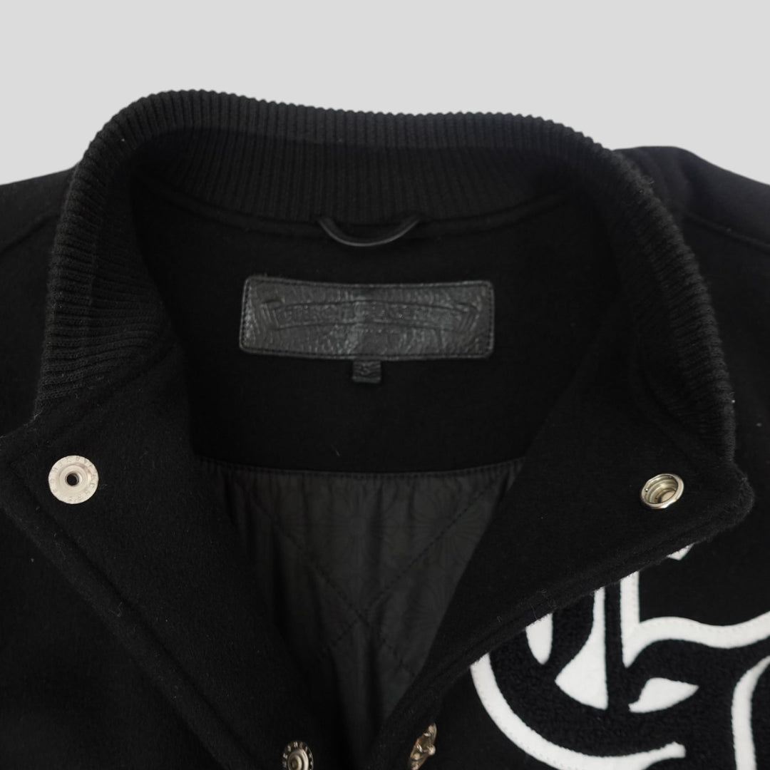 Close-up of a black jacket with a brand label on a light gray background