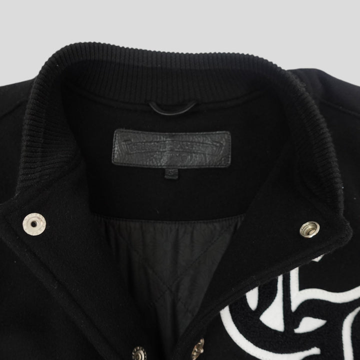 Close-up of a black jacket with a brand label on a light gray background