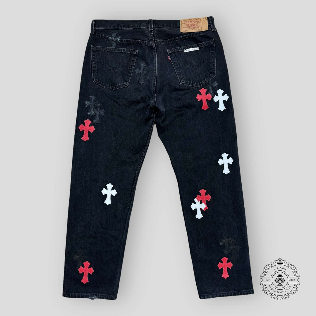 Black jeans with colorful cross patterns on a white background