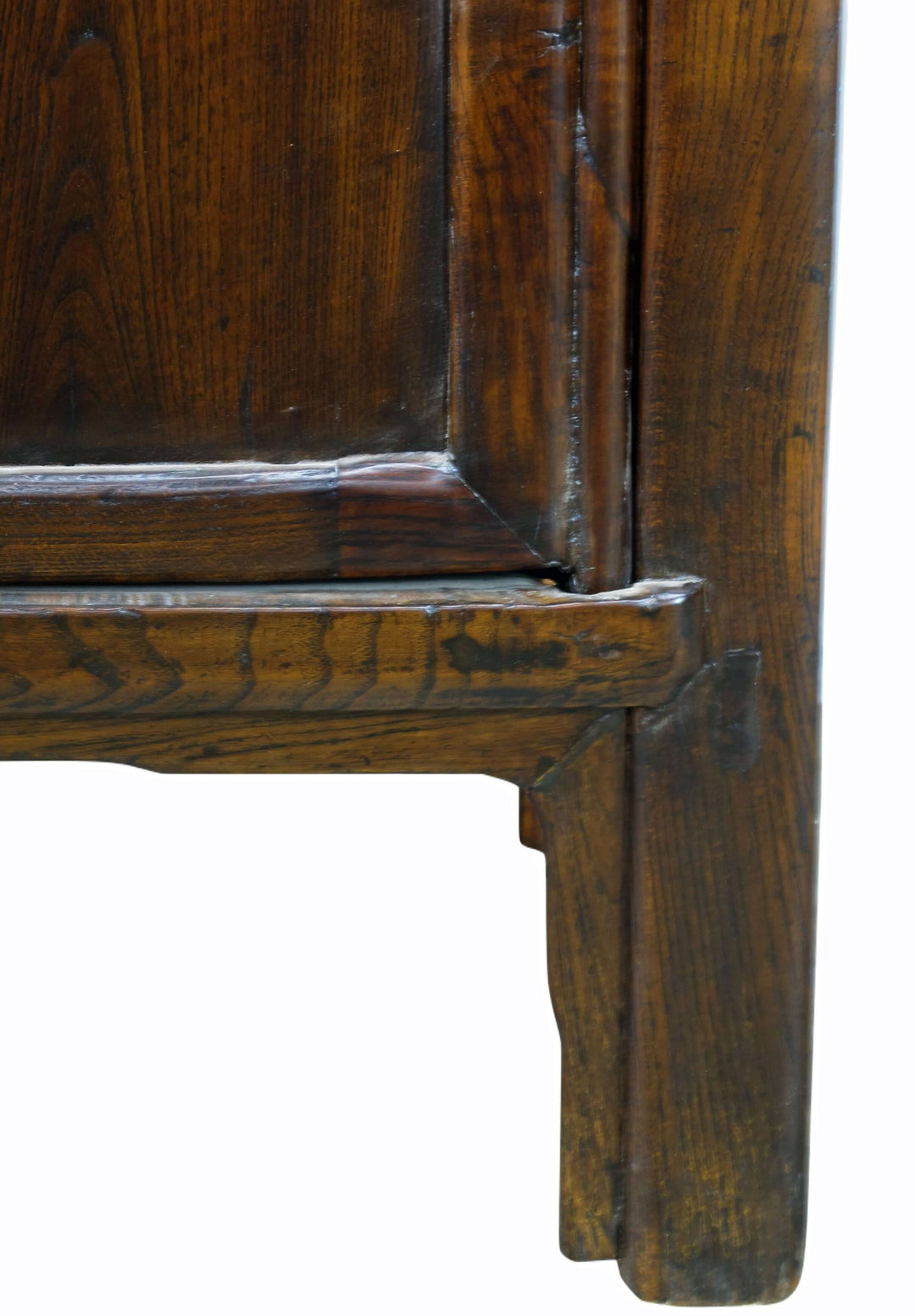 Close-up of a wooden cabinet corner with visible grain and texture.