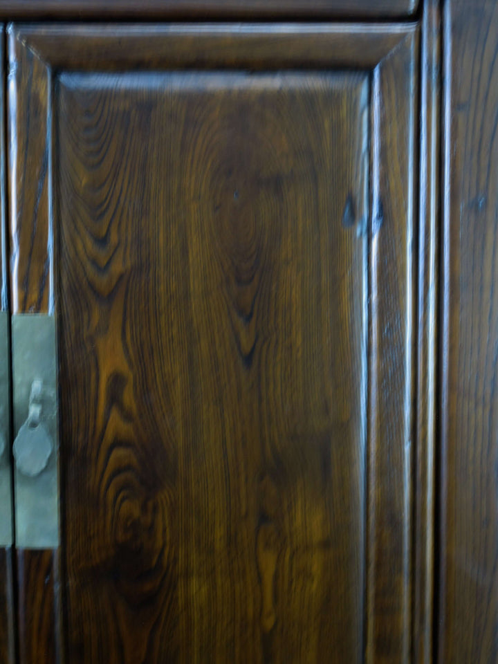 Close-up of a wooden cabinet door with visible grain and texture.
