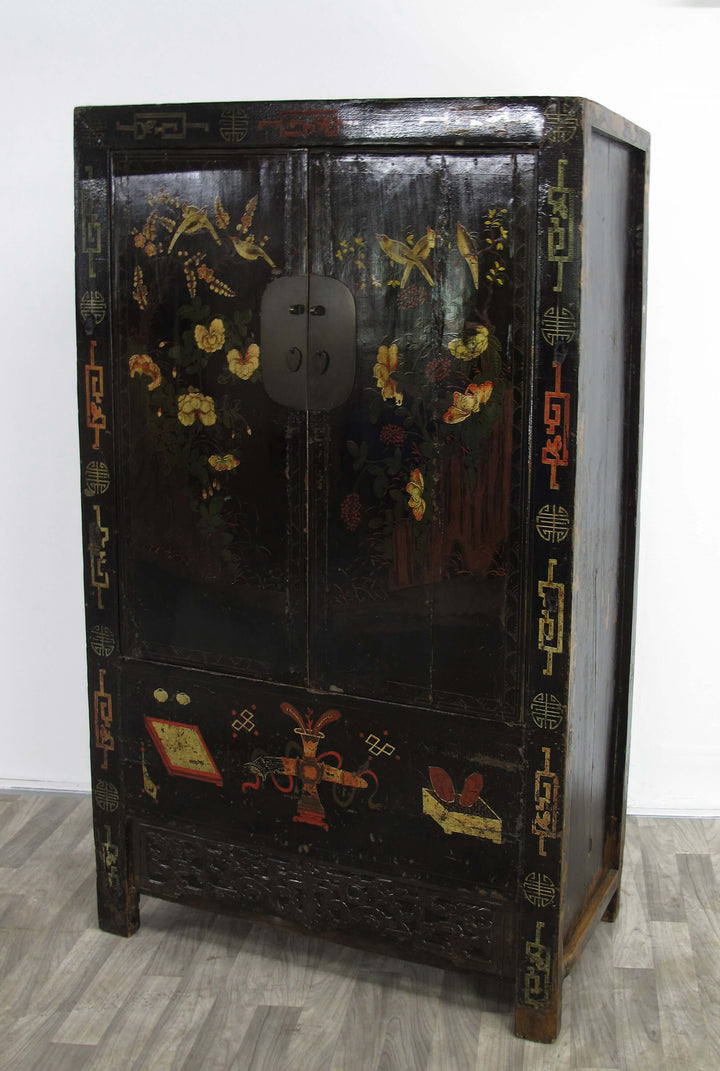 Decorative black cabinet with gold and red designs on a white background