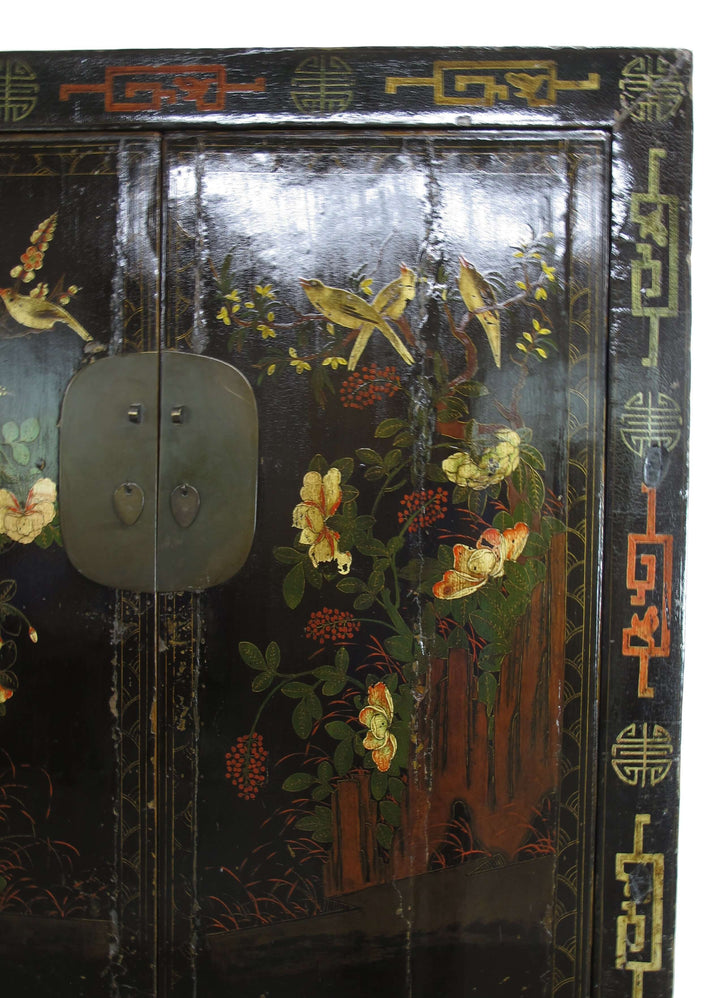 Decorative wooden cabinet with floral and bird patterns on a black background