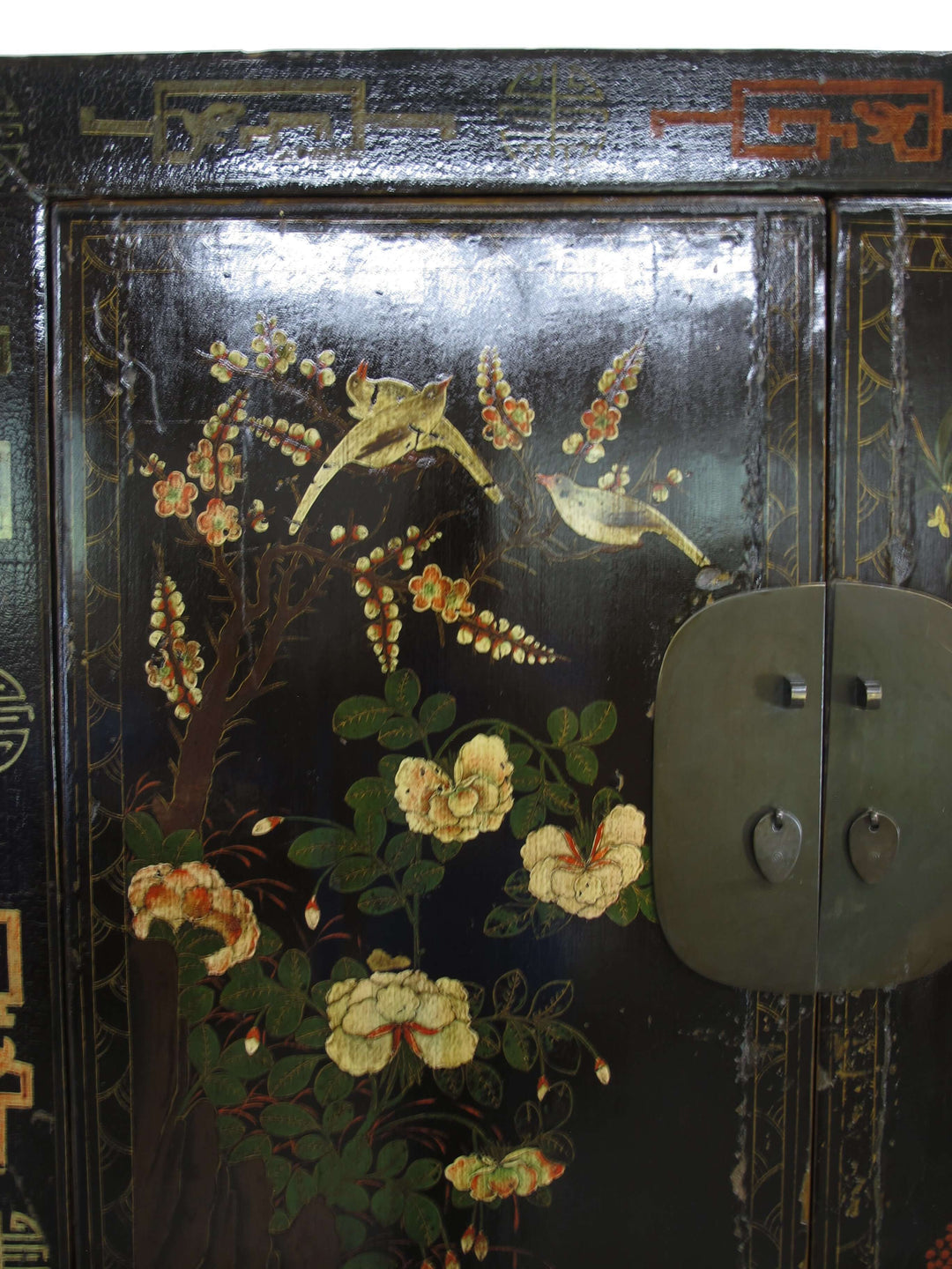 Decorative wooden panel with floral and bird design on a black background