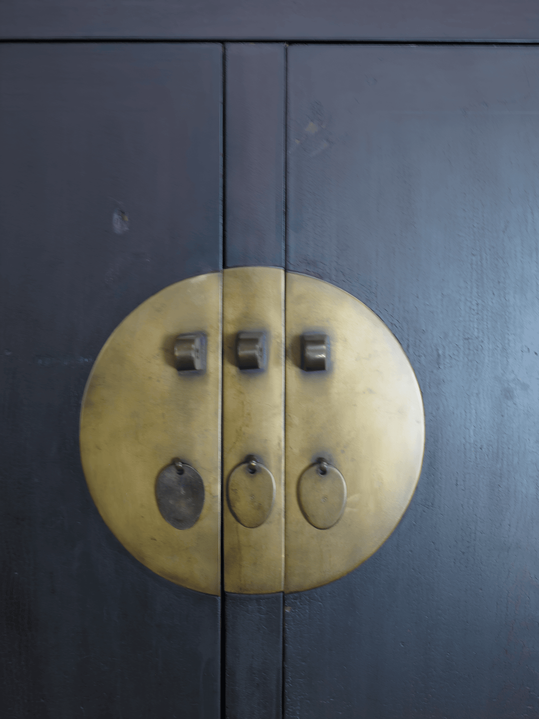 Brass circular handle on a dark wooden door