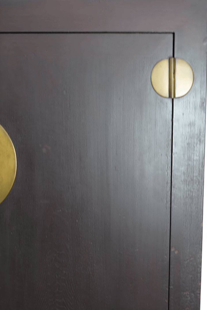 Dark wooden cabinet with gold circular handles