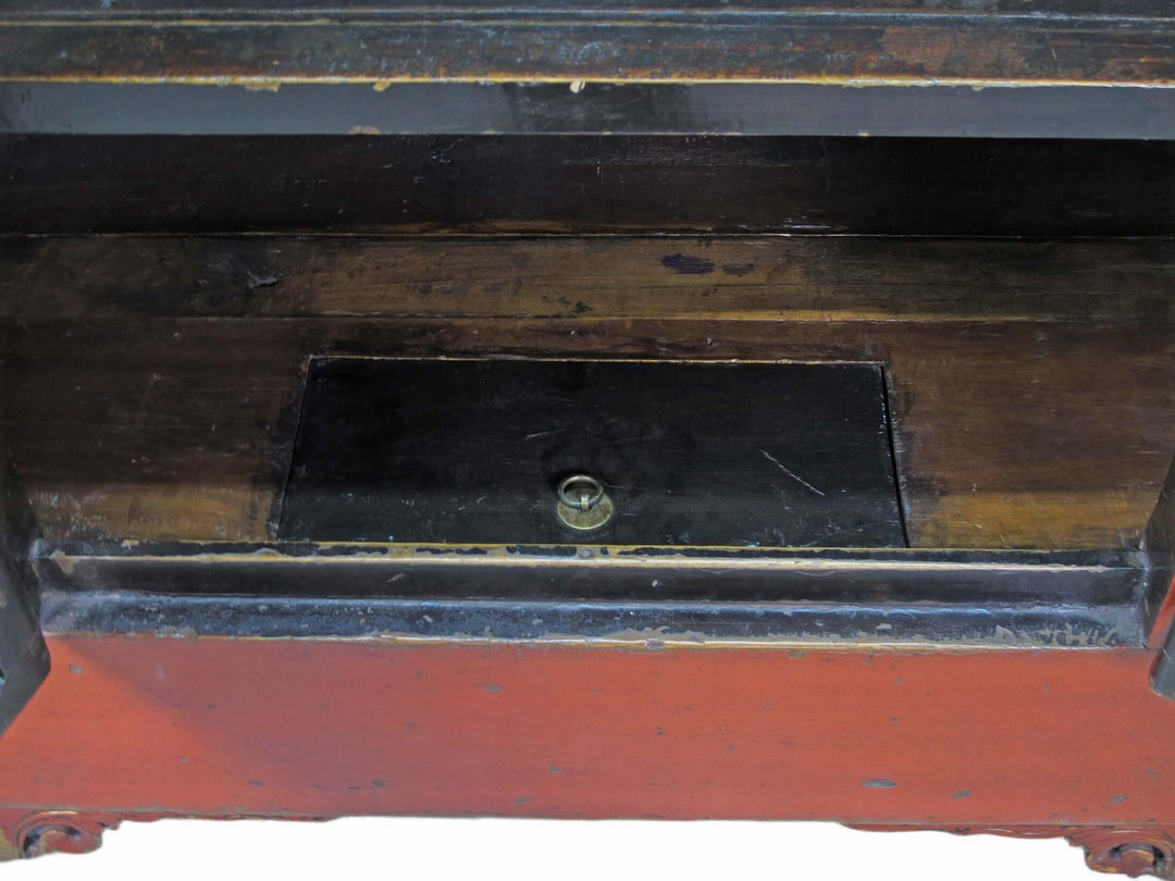 Close-up of an old wooden desk with a metal lock, showing signs of wear.