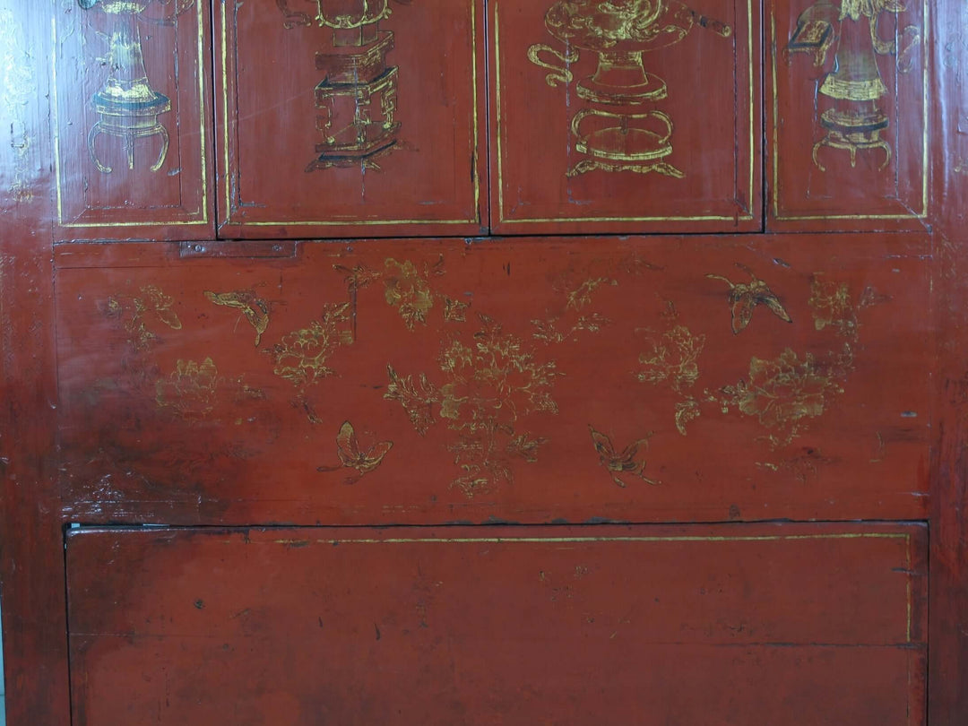 Red wooden cabinet with gold floral and leaf patterns