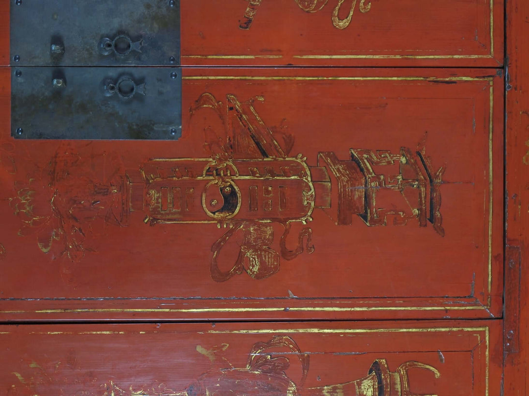 Red wooden cabinet with gold intricate carvings and metal accents