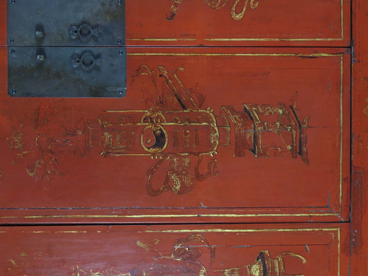 Red wooden cabinet with gold intricate carvings and metal accents