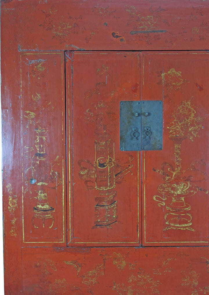 Red wooden cabinet with gold decorative elements and a blue handle.