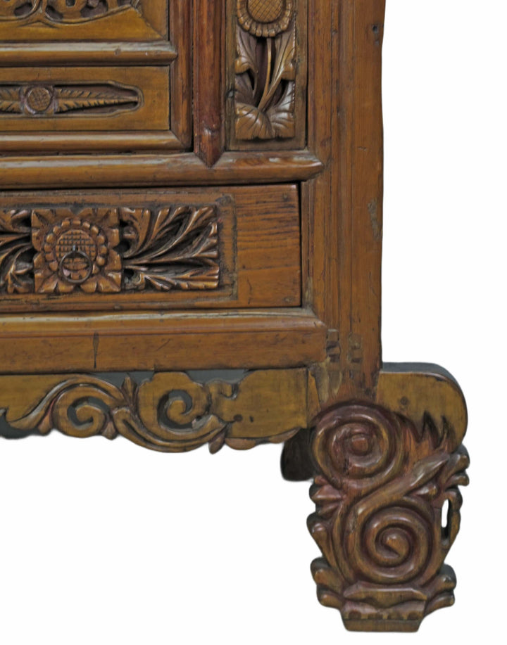 Close-up of a wooden cabinet with intricate carvings on a white background