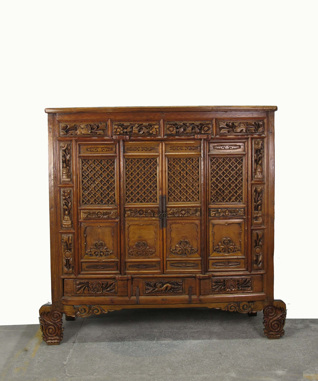 Decorative wooden cabinet with intricate carvings on a plain background