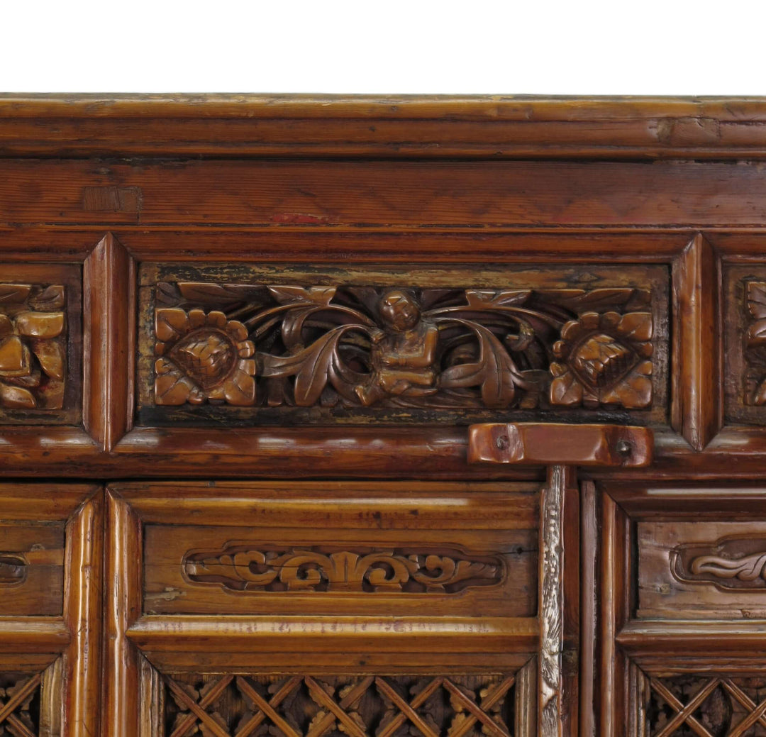 Close-up of a wooden cabinet with intricate carvings on a white background