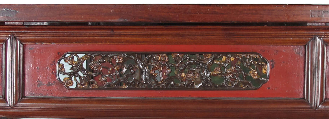 Decorative wooden panel with intricate carvings and a red background