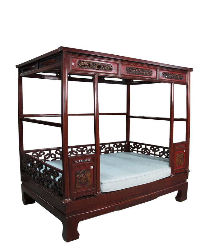Traditional wooden bed with canopy on a white background