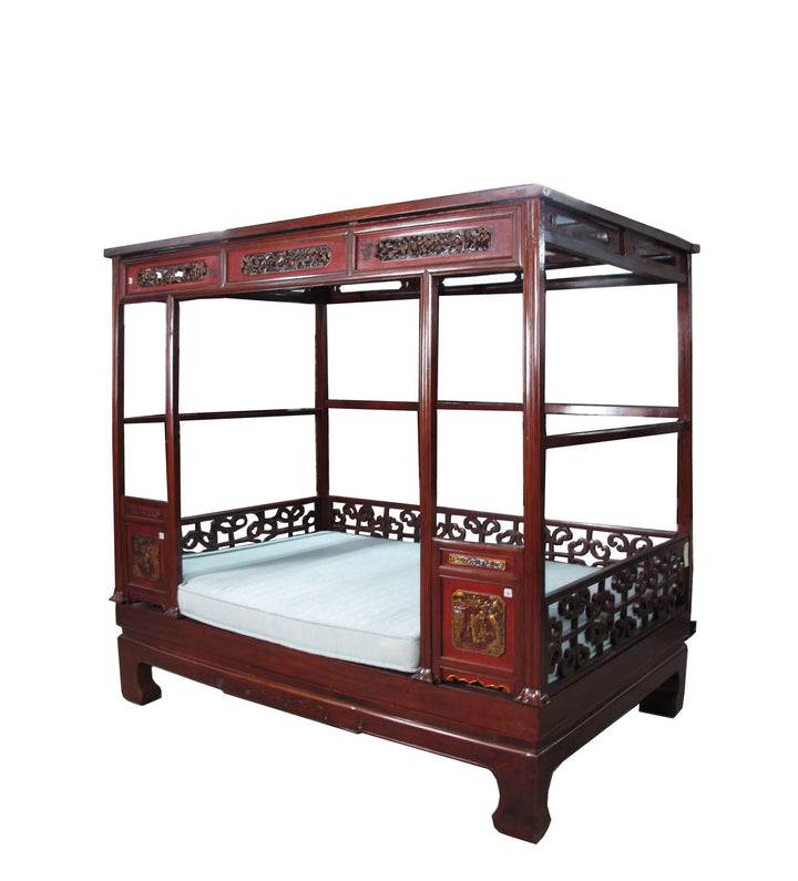 Traditional wooden bed with intricate carvings on a white background