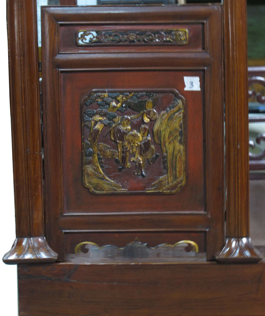 Wooden panel with decorative carvings and a plaque featuring a horse and rider scene.
