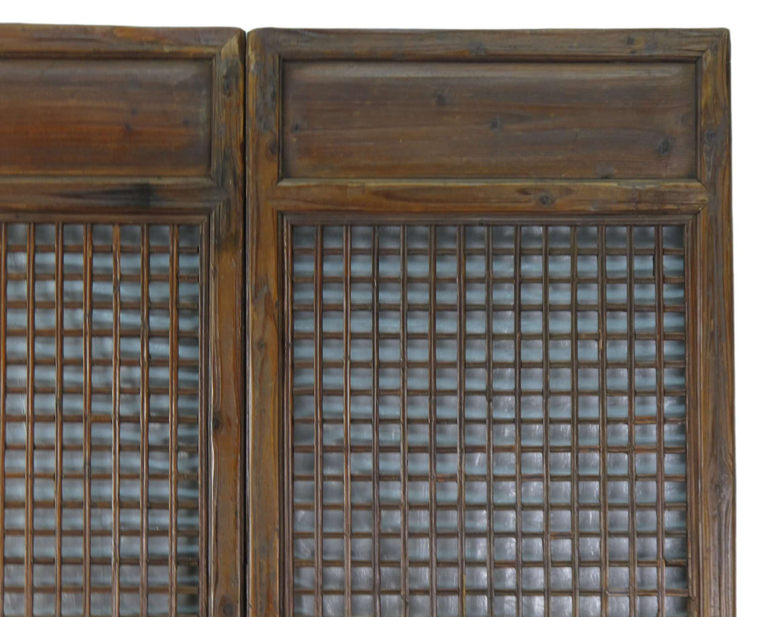 Pair of wooden cabinet doors with grid patterns on a white background