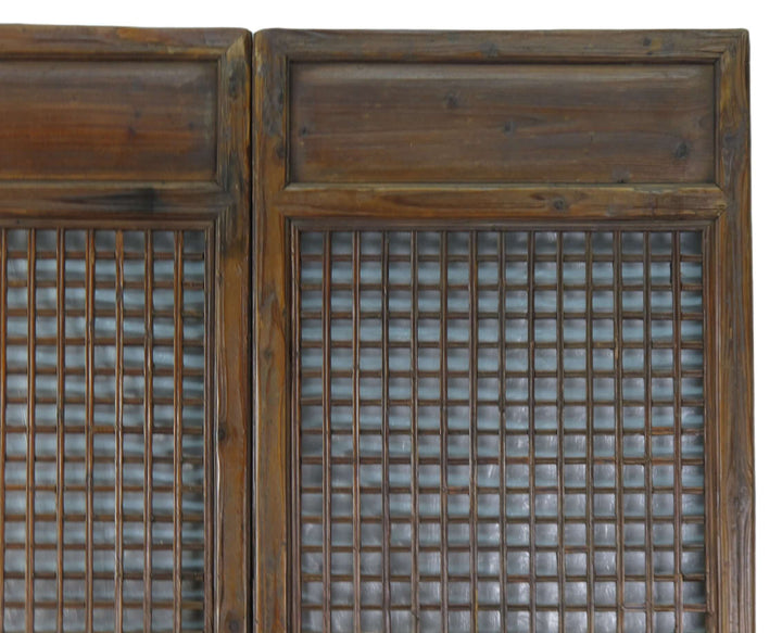 Pair of wooden cabinet doors with grid patterns on a white background