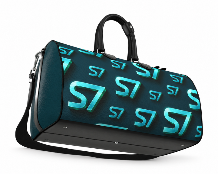 S7 Electric Lagoon bag featuring dimensional turquoise monograms, midnight teal side panels, and nickel-tone hardware.