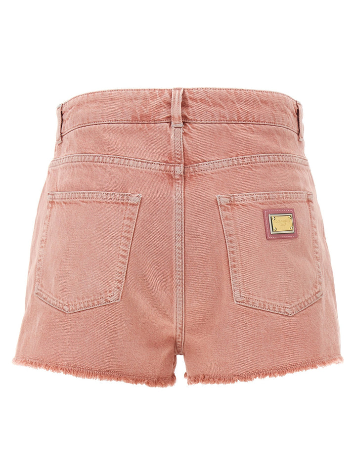 Pink denim shorts with a brand label on a white background