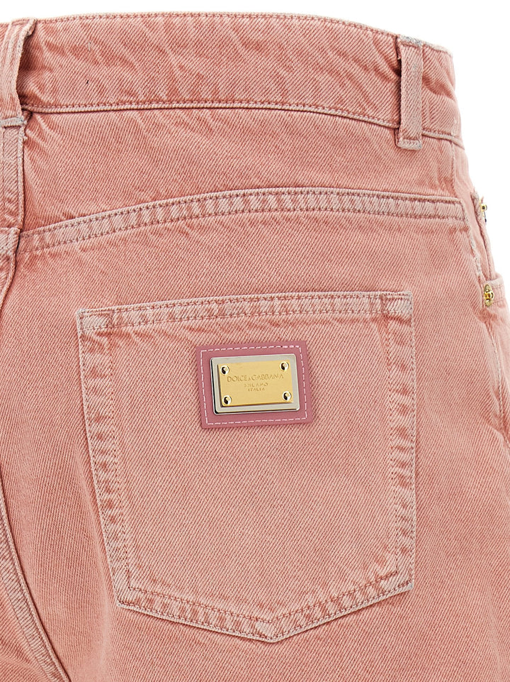 Close-up of a pink denim pocket with a brand label on a white background