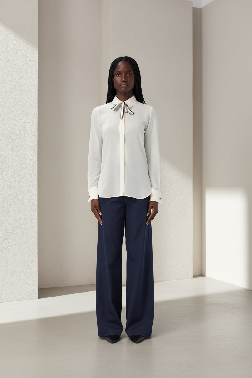 White blouse with a bow tie worn by a person on a white background