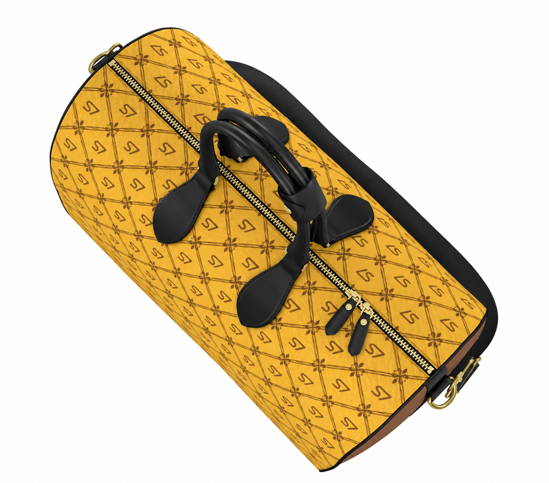 A yellow quilted duffel bag with a repeating monogram pattern, black leather handles, and gold-tone zippers, shown on a plain white background.