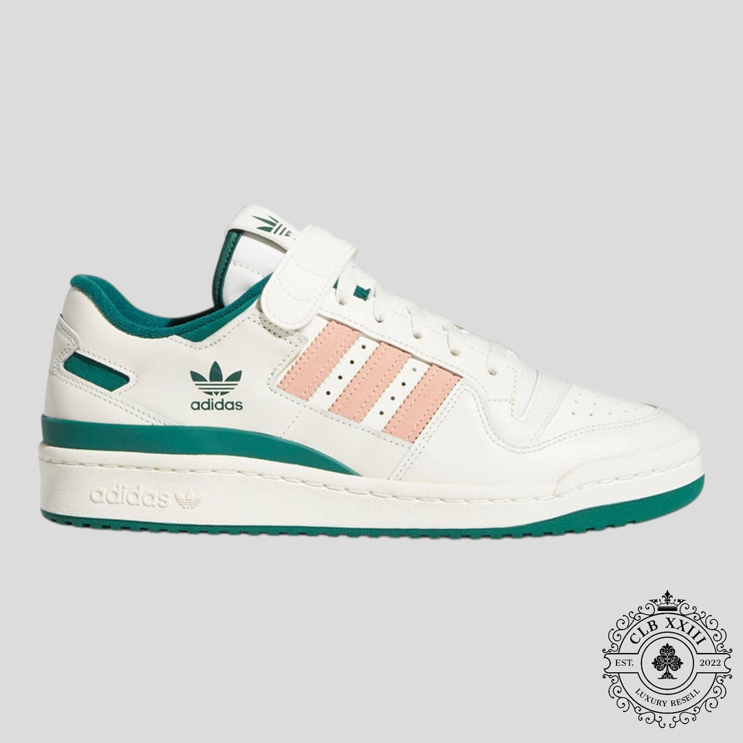 White Adidas sneaker with green accents on a gray background