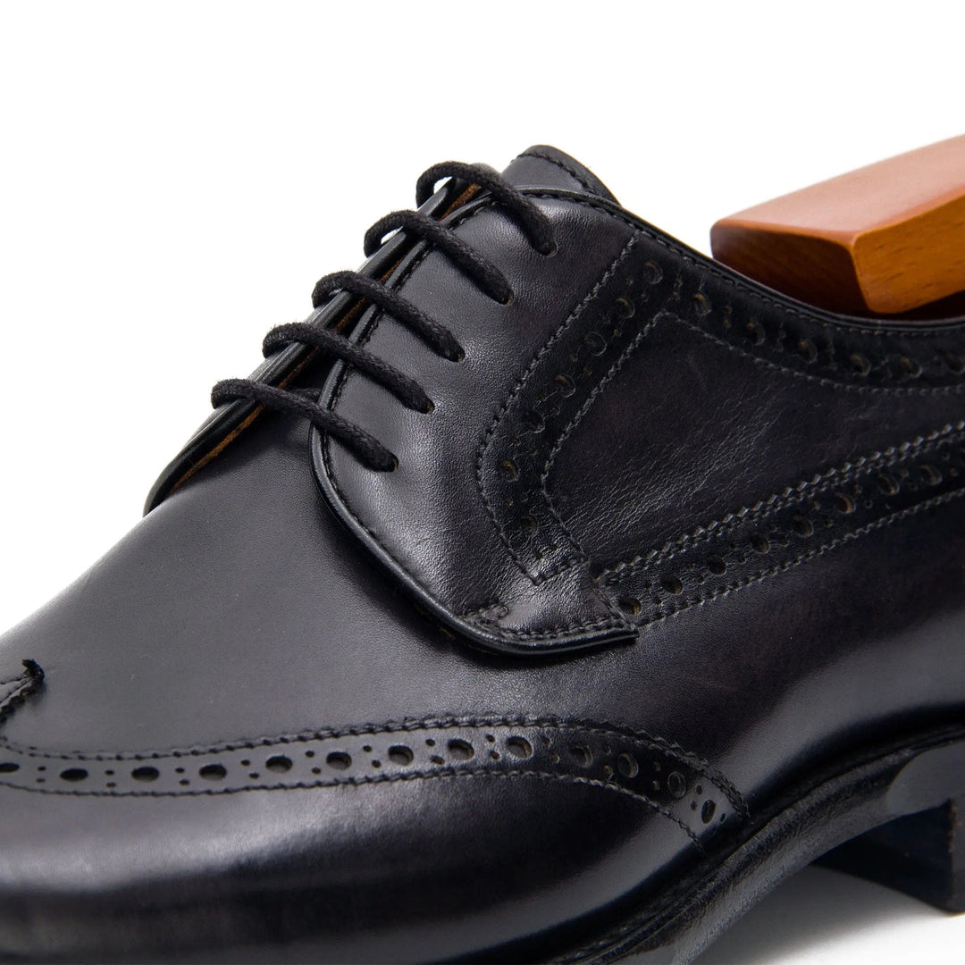 Goodyear Welt Brogue Shoes in black calfskin leather, detailed view showing U-wing design and brogue perforations.
