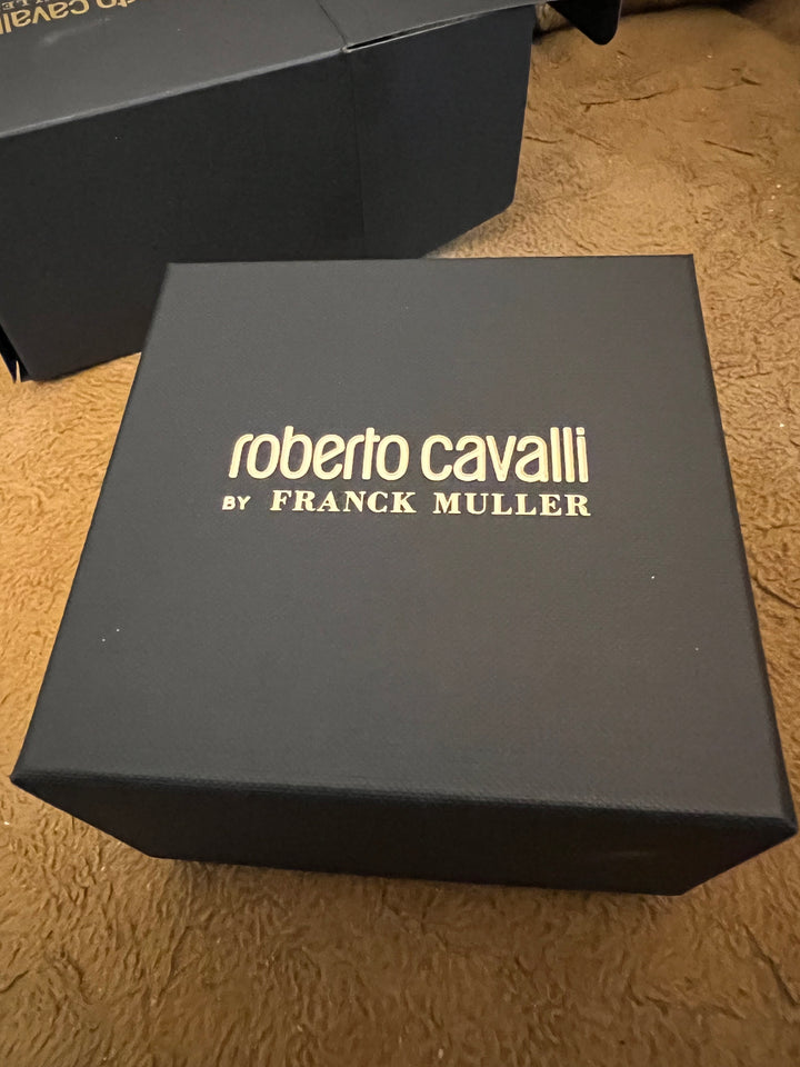 A dark charcoal gray rectangular box with gold vertical text reading &