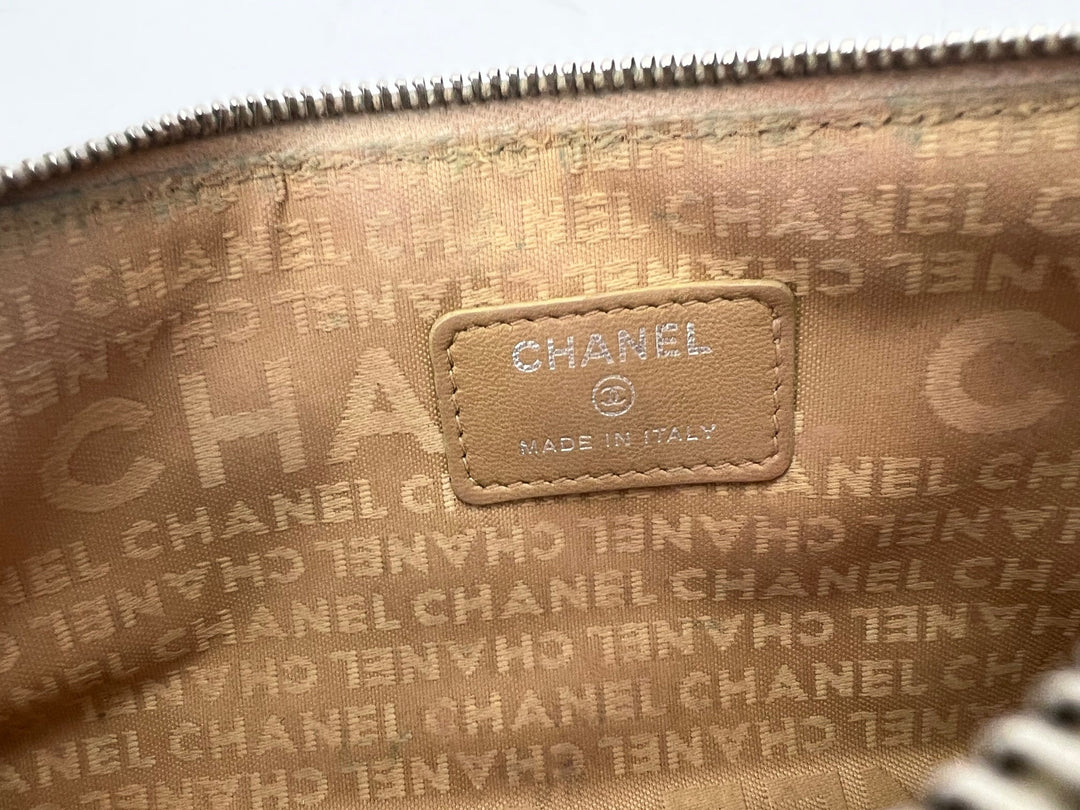Close-up of a Chanel handbag with logo and text pattern.