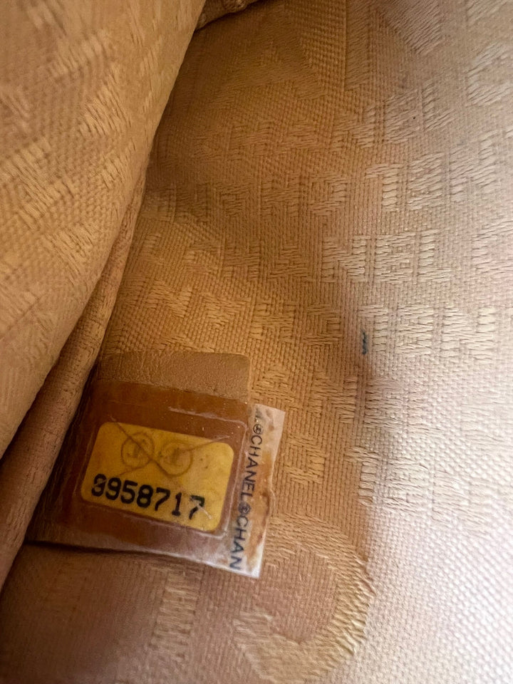 Close-up of a brown fabric with a label featuring a pattern and text.