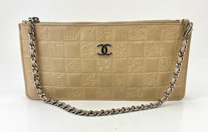 Beige handbag with chain detail and Chanel logo on a white background