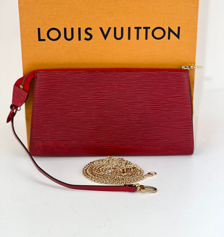 Red Louis Vuitton wallet with gold chain on a white background
