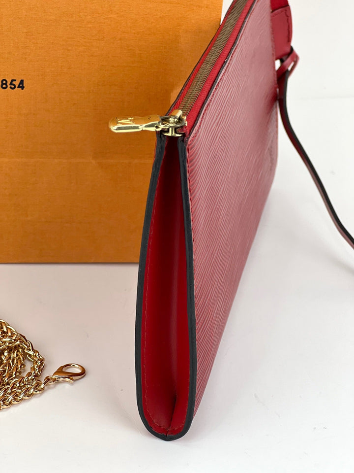 Red handbag with gold chain and box on a white background